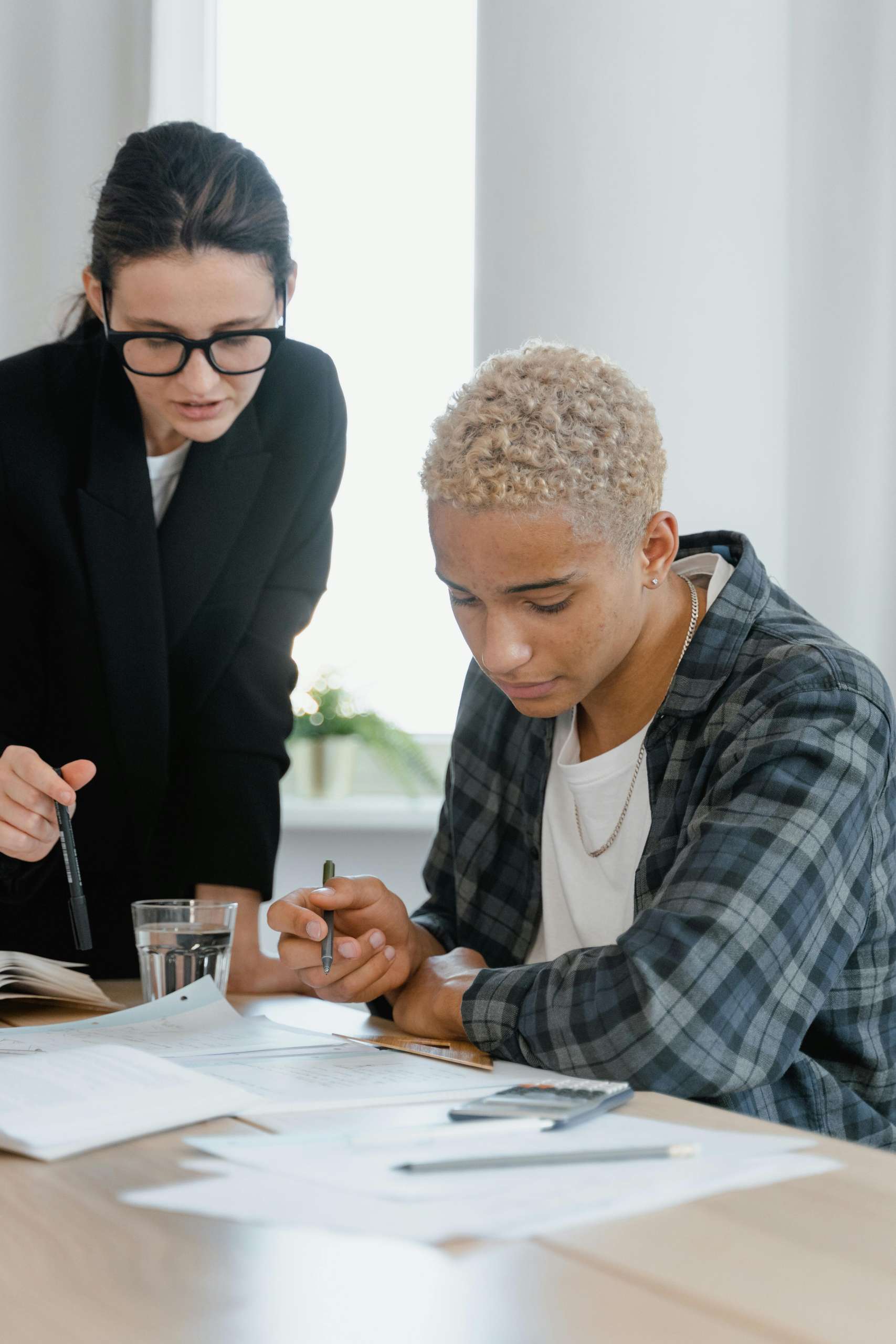 Image of 2 people filling out papers